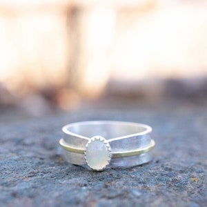Opal solitaire ring set into sterling silver.  Many sizes available.  The Ethiopian Opal gemstone is oval, 7 x 4mm in size.
