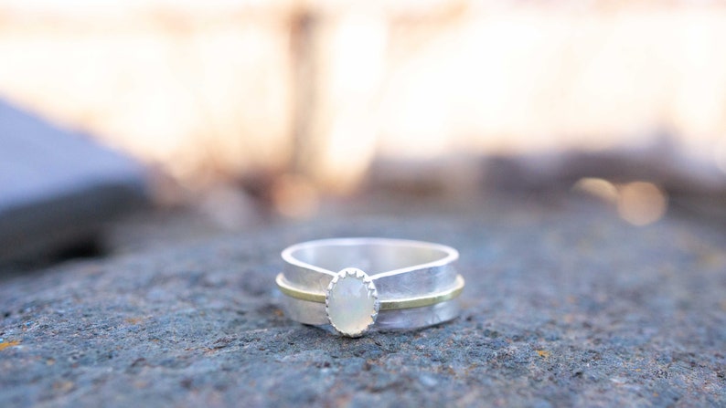 Opal solitaire ring set into sterling silver.  Many sizes available.  The Ethiopian Opal gemstone is oval, 7 x 4mm in size.