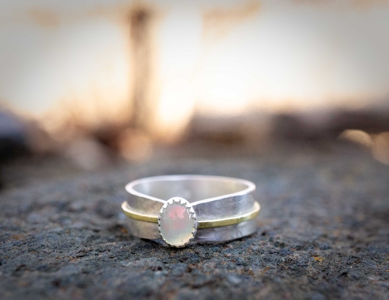 Opal solitaire ring set into sterling silver.  Many sizes available.  The Ethiopian Opal gemstone is oval, 7 x 4mm in size.