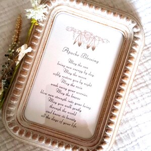 May include: A rectangular picture frame with a distressed white and brown beaded border containing a printed Apache Blessing. The text reads: May the sun bring new energy by day. May the moon softly restore you by night. May the rain wash away your worries.