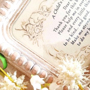 May include: A rectangular wooden frame with a distressed white finish and beaded edges, containing a print with a brown ink illustration of rabbits and the text: A Child's Prayer, Dear God, Thank you for this day. Please help me in every way, to be kind, and good, and true, and every little thing I do. Make me strong to do what's right, to do my best with all my might. Amen.