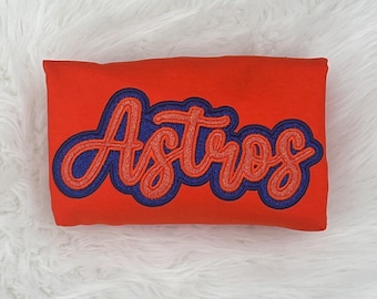 May include: Red sweatshirt with a blue and red embroidered "Astros" logo.