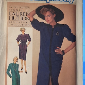 Puede incluir: Patrón de costura Simplicity número 6681, La Collection Signée De, Lauren Hutton Signature Collection. El patrón presenta tres diseños de vestidos diferentes. El primer vestido es un vestido largo azul con un frente abotonado y una abertura en el frente. El segundo vestido es un vestido verde más corto con un frente abotonado. El tercer vestido es un vestido negro con un frente abotonado y un cinturón.