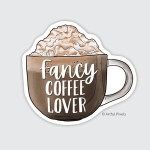 May include: A sticker featuring a brown coffee mug filled with coffee and topped with whipped cream. The text "Fancy Coffee Lover" is written in white script on the mug. The sticker has a white border.