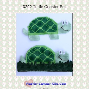 May include: A set of two green turtle-shaped coasters with smiling faces. The turtles are made of plastic canvas and are sitting on a green background. The coasters are part of a craft kit and are available for purchase on the website Plastic-Canvas-Kits.com.