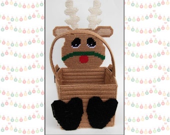 May include: A plastic canvas kit to make a brown and white reindeer-shaped basket with black heart-shaped feet. The kit includes instructions and all the materials needed to create the basket. The text on the image reads "1323 Square Christmas Reindeer Basket" and "Plastic-Canvas-Kits.Com".
