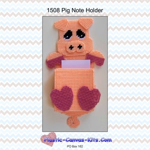 Puede incluir: Un porta notas de plástico de color rosa en forma de cerdo con un bloc de notas blanco. El cerdo tiene orejas rosas, un hocico rosa y ojos negros. El cerdo está sosteniendo el bloc de notas en sus patas delanteras. El porta notas es un proyecto de artesanía y está disponible como patrón.
