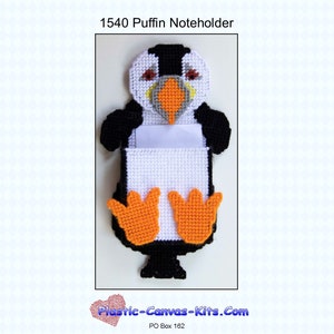 May include: A white plastic canvas craft kit of a puffin note holder. The puffin is black, white, orange, and gray. The note holder is white with a black border. The kit is titled "1540 Puffin Noteholder".