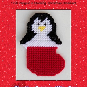 May include: A plastic canvas pattern for a penguin wearing a red stocking. The pattern is for a Christmas ornament and includes the text "1729 Penguin in Stocking Christmas Ornament" and "Plastic-Canvas-Kits.com".