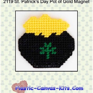 May include: A black pot of gold magnet with a yellow gold top and a green shamrock. The magnet is decorated with a white background with a pattern of green shamrocks.