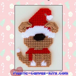 May include: A plastic canvas pattern for a Santa gnome dog ornament. The dog is wearing a red hat with a white pom-pom and a red scarf. The pattern is brown, white, and red.
