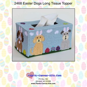 May include: A light blue tissue box cover featuring three dogs wearing Easter bunny ears. The box is decorated with clouds, Easter eggs, and the text "2468 Easter Dogs Long Tissue Topper".