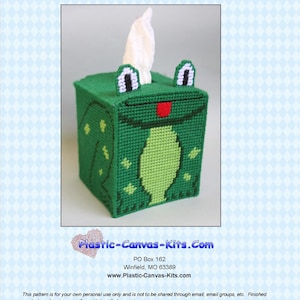 May include: Green frog tissue box cover with white eyes and a red mouth. The tissue box cover is made of plastic canvas and is a craft project.