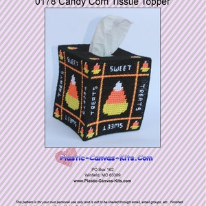 May include: A black, square tissue box cover with a candy corn design. The cover features orange, yellow, and white candy corn graphics, with the words "SWEET" and "TREATS" in white. The tissue box is made of plastic canvas.