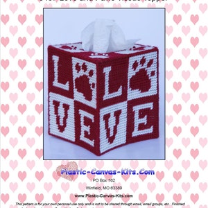 Op de afbeelding: Een rood-witte tissueboxhoes met de woorden "LOVE" en pootafdrukken. De tissueboxhoes is gemaakt van plastic canvas en heeft een vierkante vorm. De tekst "0487 Love and Paws Tissue Topper" staat bovenaan.