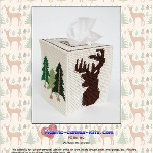 May include: A white plastic canvas tissue box cover featuring a brown deer silhouette and green trees. The cover is designed for stitching with plastic canvas needlepoint.