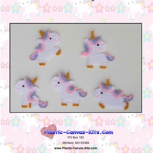 Pode incluir: Quatro kits de tela de plástico para fazer ímãs de unicórnio. Cada kit apresenta um unicórnio branco com detalhes rosa e roxo, um chifre dourado e cascos dourados. Os kits estão dispostos em um padrão quadrado sobre um fundo rosa com um padrão floral branco.