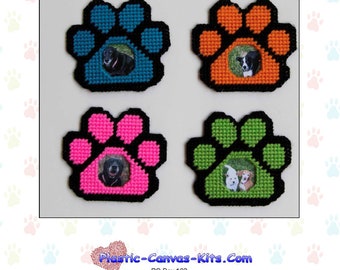 May include: Four plastic canvas paw print frames with black outlines. The frames are in blue, orange, pink, and green. Each frame has a photo of a dog inside.