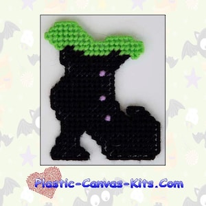 May include: A black witch boot with a green top and purple accents. The boot is a plastic canvas pattern for a magnet. The text "2001 Witch Boot Magnet" and "Plastic-Canvas-Kits.Com" are visible in the image.