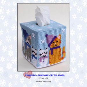 Può includere: Un copri scatola di fazzoletti in tela plastica blu con una scena invernale con tre gatti che indossano cappelli e sciarpe. I gatti sono circondati da fiocchi di neve. Il testo "Plastic-Canvas-Kits.Com" è stampato nella parte inferiore dell'immagine.