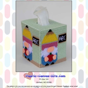 Op de afbeelding: Een tissueboxhoes van plastic canvas met een school-gnome-thema. De hoes heeft twee gnomes, een met een appel en de andere met een potlood. De gnomes dragen gele en rode hoeden en hebben zwarte baarden. De tissueboxhoes is groen en heeft de letters "ABC" erop.