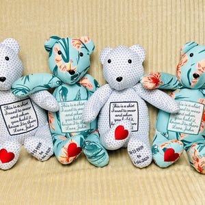 May include: Four stuffed teddy bears made from fabric. Two bears feature a white fabric with small blue dots, while two feature a light blue fabric with a floral pattern. Each bear has a patch with the text: This is a shirt I used to wear and when you hold it, know I'm there Love, John.