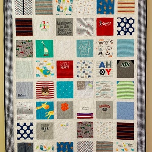 May include: A memory quilt composed of various fabric squares featuring diverse patterns, animal prints, and text including Assistant to the Regional Manager, Varsity, Ahoy, Baby Bear, and Georgia. The quilt has a blue and white gingham border.