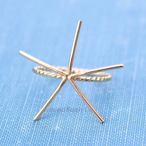 May include: Gold ring setting with six prongs, designed to hold a gemstone. The ring is made of twisted wire.
