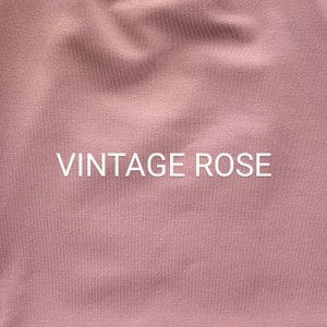 May include: Close-up of a soft, textured fabric in a vintage rose color. The fabric has a subtle ribbed texture. The text "Vintage Rose" is printed in white on the fabric.