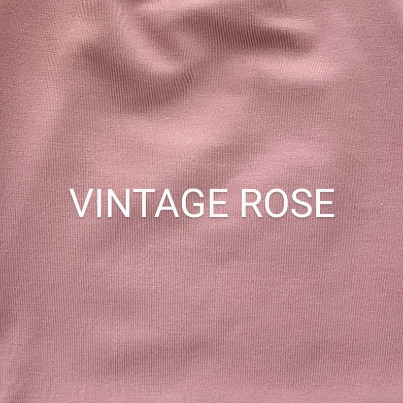 May include: Close-up of a soft, textured fabric in a vintage rose color. The fabric has a subtle ribbed texture. The text "Vintage Rose" is printed in white on the fabric.