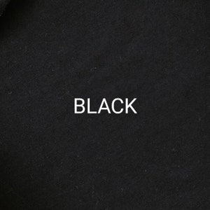 Pu&ograve; includere: Primo piano di un tessuto nero con la parola "BLACK" stampata in bianco.