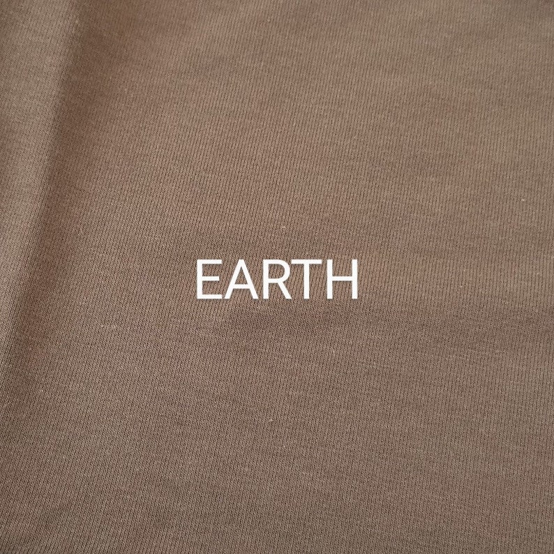 Pu&ograve; includere: Primo piano di un tessuto marrone con una texture sottile. La parola "EARTH" &egrave; stampata in lettere bianche sul tessuto.