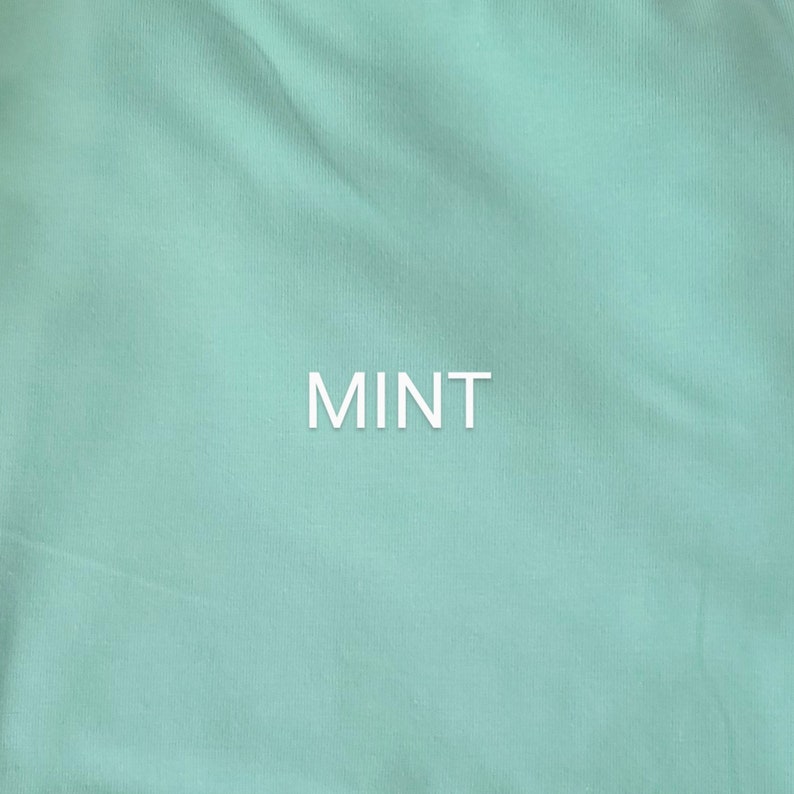 May include: A close-up of a smooth, mint green fabric. The word "MINT" is printed in white in the center of the image.
