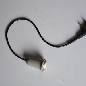 May include: A black electrical cord with a white plastic plug on one end and a black plastic plug on the other end.