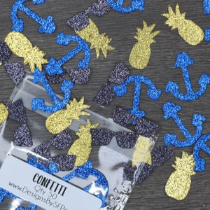 May include: Glitter confetti in a clear bag with shapes of anchors, sunglasses, and pineapples. The confetti is blue, gold, and dark blue. The bag has a label that says "Confetti" and "Qty 50".