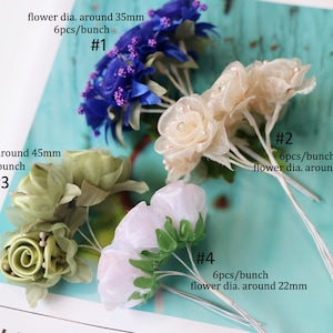 May include: Four bunches of artificial flowers in different colors and sizes. The flowers are made of fabric and have a delicate, ruffled texture. The bunches are labeled with numbers and descriptions of the flower size and quantity per bunch. #1 is blue, #2 is cream, #3 is green, and #4 is white.