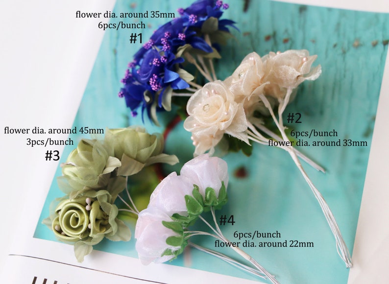 May include: Four bunches of artificial flowers in different colors and sizes. The flowers are made of fabric and have a delicate, ruffled texture. The bunches are labeled with numbers and descriptions of the flower size and quantity per bunch. #1 is blue, #2 is cream, #3 is green, and #4 is white.