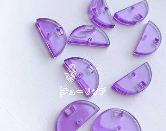 May include: A set of ten purple, semi-circle shaped plastic buttons with a hole in the center. The buttons are translucent and have a slightly frosted appearance.