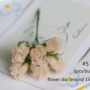 May include: A bunch of six small, beige fabric roses with green leaves. The roses are about 1.5 inches in diameter. #5 6pcs/bunch flower dia. around 15mm