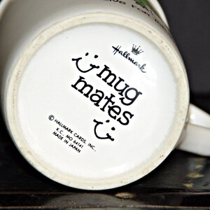 May include: White ceramic mug with a black and white design that says "mug mates" with a crown and the word "Hallmark" on the bottom. The mug is made in Japan.