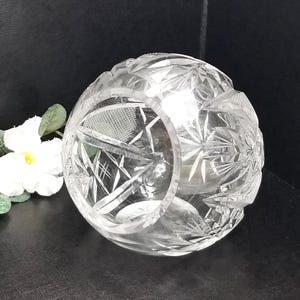 Pode incluir: Uma tigela de vidro transparente com um design de cristal cortado. A tigela é redonda e tem uma abertura larga.