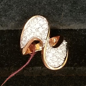 May include: A gold ring with a swirling design, set with small, clear stones.