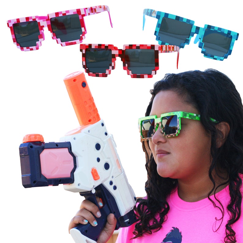 May include: A person wearing green, blue, and red pixelated sunglasses holds a white and orange water gun. The sunglasses have a pixelated design.