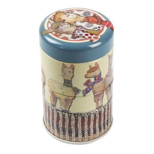 May include: A stackable tin container with a blue lid and three sections. The lid features illustrations of alpacas. The middle section has alpaca illustrations wearing scarves. The bottom section has a brown and white knit pattern.