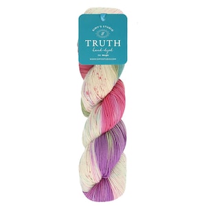 May include: A skein of hand-dyed yarn in a multi-colored gradient pattern. The yarn is a mix of cream, pink, purple, and green. The yarn is labeled "Truth hand-dyed" with the company name "Simy's Studio".
