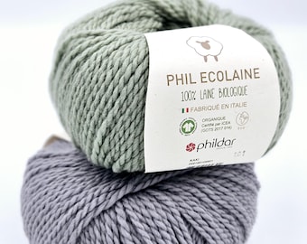 May include: Two skeins of yarn, one green and one gray, with a label that reads "Phil Ecolaine 100% Laine Biologique Fabriqué en Italie Organique Certifié par ICEA (GOTS 2017 014) phildar KAKI 101".