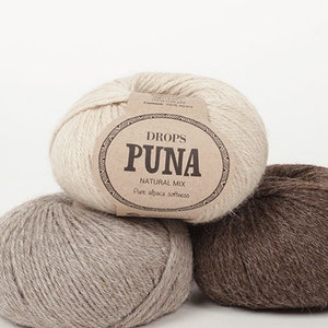 May include: Three balls of Drops Puna Natural Mix yarn in cream, gray, and brown. The cream-colored ball has a label that reads "Drops Puna Natural Mix Pure alpaca softness."