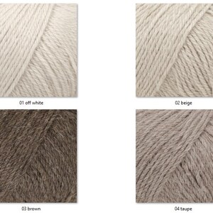 May include: Close-up of four skeins of yarn in various neutral colors: off-white, beige, brown, and taupe. Each skein is labeled with its color name and number. The yarn appears soft and textured, suitable for knitting or crochet projects.