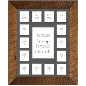 May include: A brown wooden picture frame with a gray mat and 14 openings for photos. The openings are labeled with the grades pre-school, kindergarten, and grades 1 through 11. The text "The days are long, The years are short" is printed in the center of the frame.