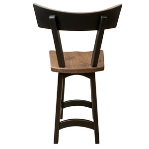 May include: Black and brown wooden bar stool with a curved back and two steps. The stool is made of solid wood and has a natural finish.
